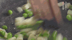 鍋中油7成熱時(shí)，入青豆、筍丁翻炒，然后加糯米飯加鹽均勻翻炒。