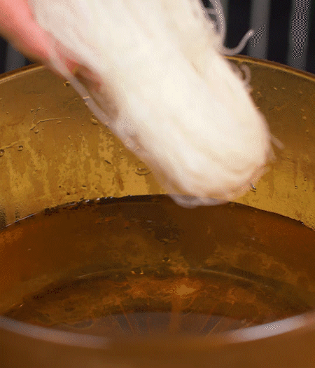 選用鮮嫩蠶豆，剝?nèi)ネ鈿ち粝露姑紫磧?，掰開成兩瓣。