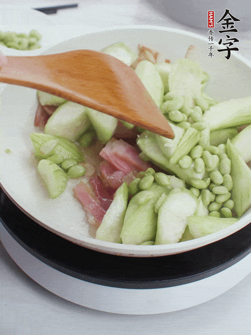 依次下絲瓜、青豆翻炒，炒至絲瓜打蔫縮小。