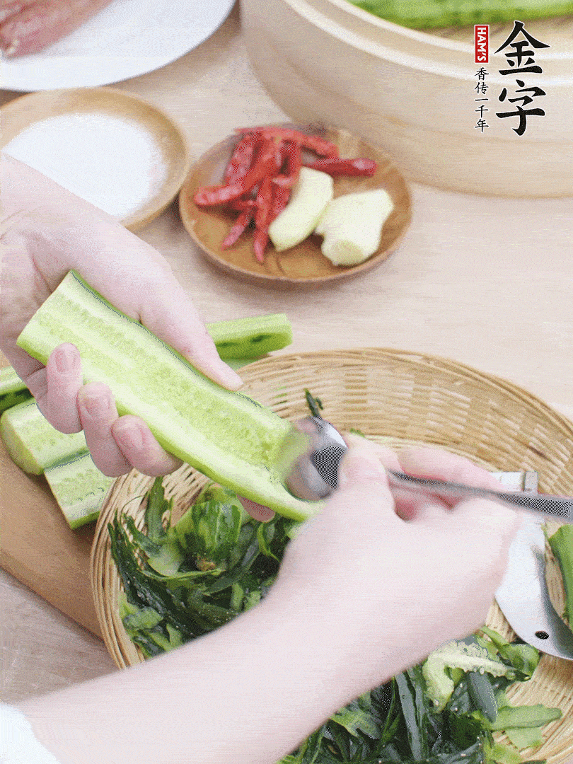 黃瓜削皮，對(duì)半切開，勺子挖去內(nèi)瓤，斜刀切片。青蒜斜刀切段。