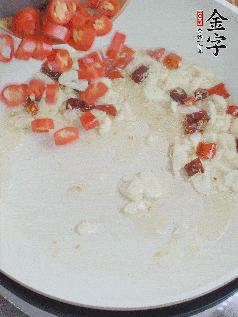 油6成熱，下蒜末、干紅辣椒煸炒，出香味后再放美人椒、香腸。