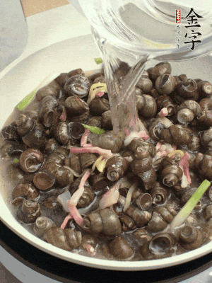 倒處理干凈的螺螄翻炒，加3勺料酒。加清水蓋過螺螄，中火蓋蓋煮5分鐘。