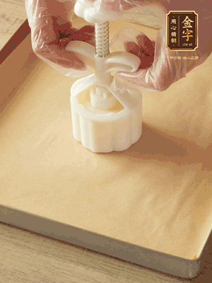 取一個(gè)面團(tuán)，捏扁，中間厚，四周薄?；⒖谕贤?，直到收口，把餅胚放入模具里，壓2-3下