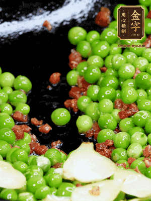 鍋內(nèi)少許油，下火腿煸香，再下甜豆米、百合翻炒，少許鹽、一點水煮到收干