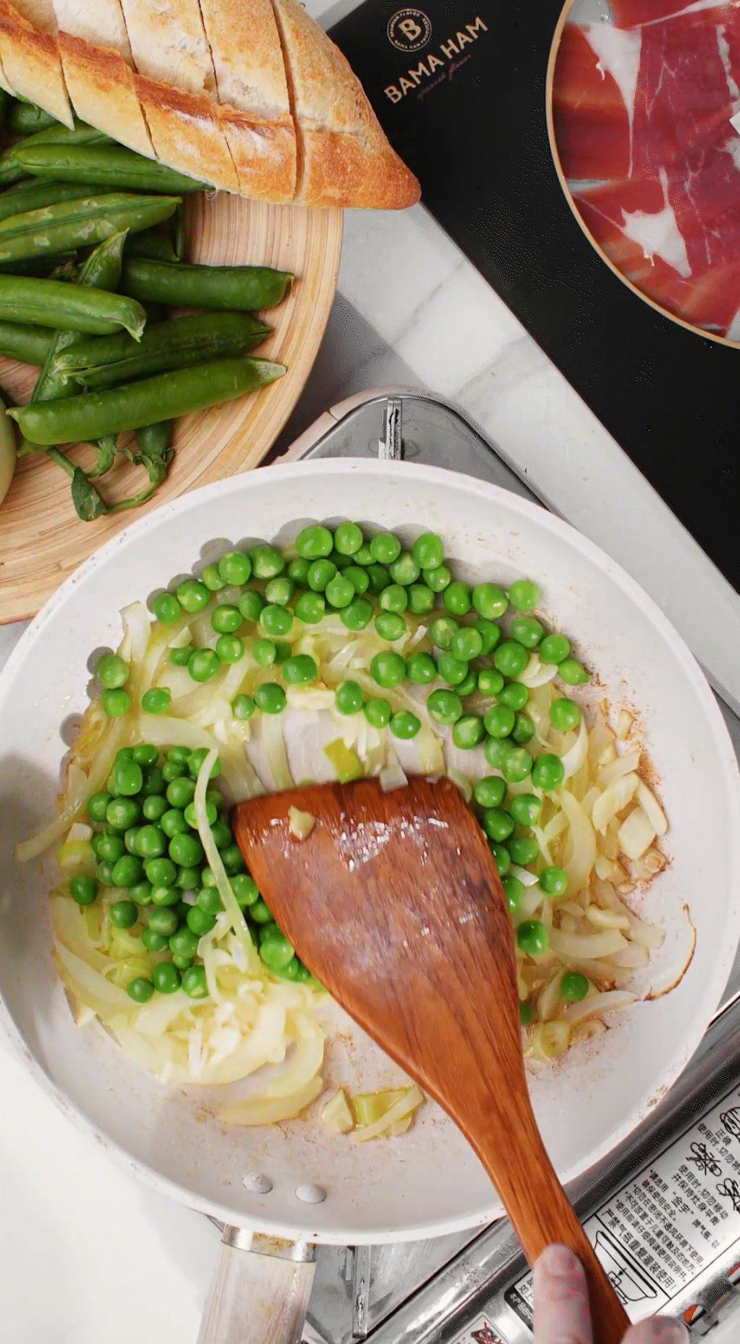 鍋中放入黃油融化，加入洋蔥絲、大蔥蔥白絲、蒜末翻炒變軟出香味。加入剛剛汆燙冰鎮(zhèn)后的豌豆，取出一點(diǎn)點(diǎn)待會(huì)擺盤裝飾用。加一點(diǎn)鹽 (和黑胡椒) 調(diào)味。