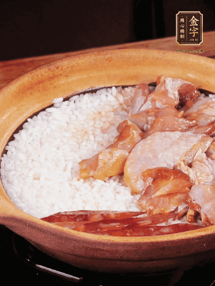 煮到椰子水微微收干轉(zhuǎn)小火，快速均勻鋪上雞肉、金字香腸